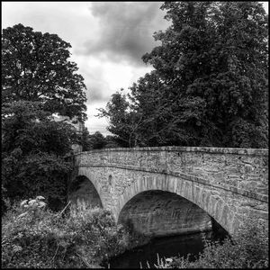 Bridge against cloudy sky