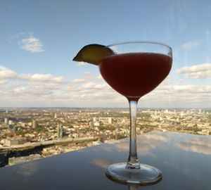 Close-up of beer in glass against cityscape