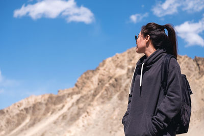 Woman looking at mountains against sky