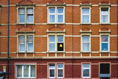 A brick facade with light shining through windows