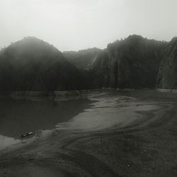 Scenic view of lake by mountains against clear sky