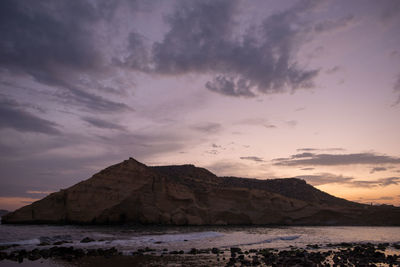 Scenic view of sea and mountains against sky during sunset