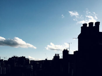 Low angle view of silhouette buildings against sky