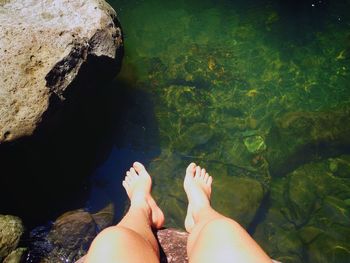 Low section of woman relaxing in water