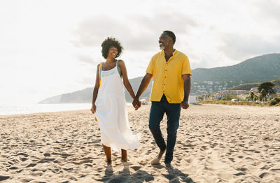 Full length of couple standing at beach