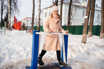 Woman on a simulator in the park goes in for sports on a sunny spring day