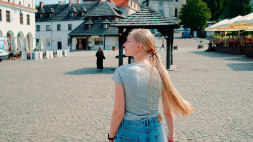 Midsection of woman standing on street in city