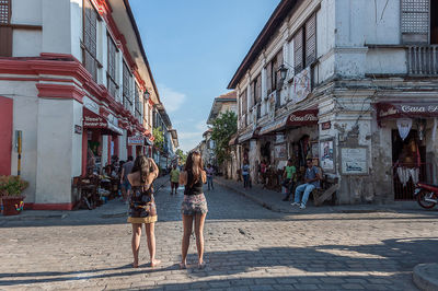 People on street amidst buildings in city