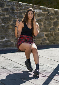 Attractive teenage girl with brown hair swinging on a swing