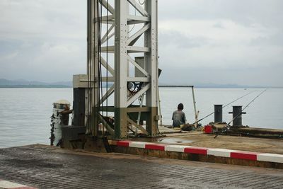 Pier on sea against cloudy sky