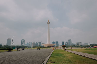 View of monument in city against cloudy sky