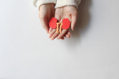 Cropped hand of woman holding gift against white background