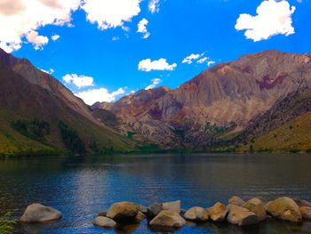 Scenic view of lake and mountains against blue sky