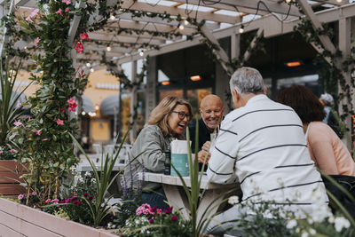 Happy male and female senior friends having fun sitting at restaurant