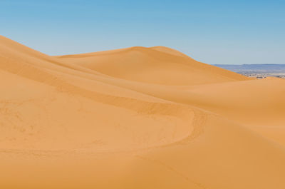 Scenic view of desert against clear blue sky