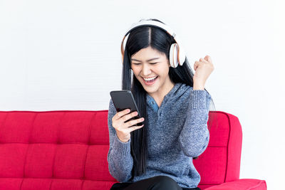 Smiling young woman using mobile phone