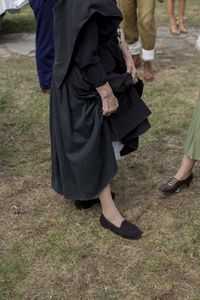 Low section of couple walking on field