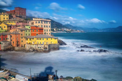 Scenic view of sea by buildings against sky