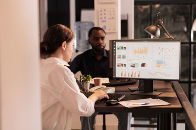 Midsection of woman using laptop at office