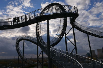 Low angle view of bridge against cloudy sky