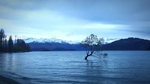 Scenic view of lake and mountains against blue sky