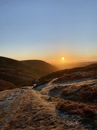 Scenic view of landscape against clear sky during sunset