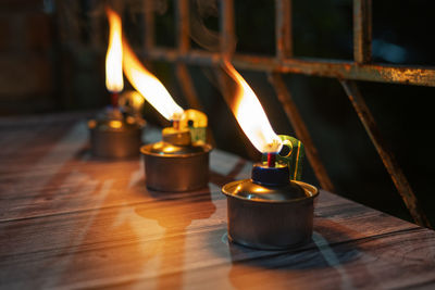 Close-up of lit tea light candles on table