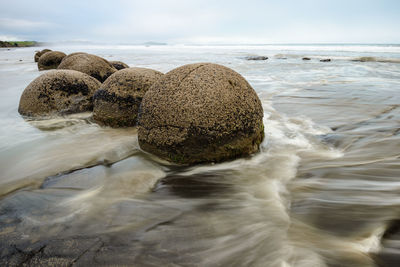 View of rocks in sea against sky