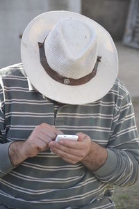 Midsection of man using mobile phone