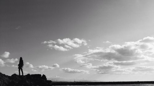 Silhouette man standing on field against sky