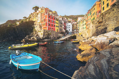 Boats moored in sea against buildings in city