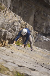 Full length of man climbing rock on mountain