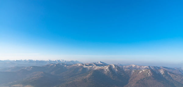 Scenic view of mountains against clear blue sky