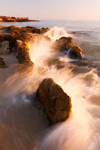 Scenic view of rocks on beach against sky