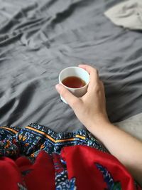 High angle view of hand holding coffee cup