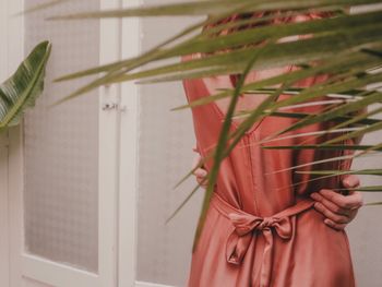 Close-up of woman standing by potted plant