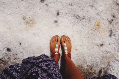 Low section of woman standing on sand