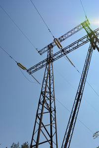 Low angle view of electricity pylon against clear sky