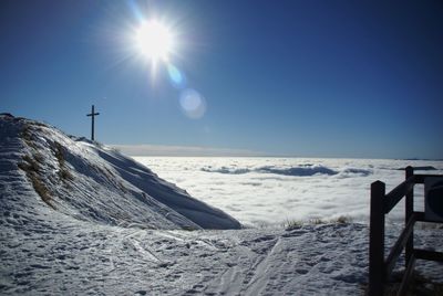 Scenic view of snow covered land against bright sun