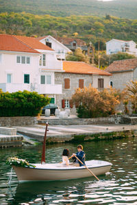 People enjoying in lake against buildings