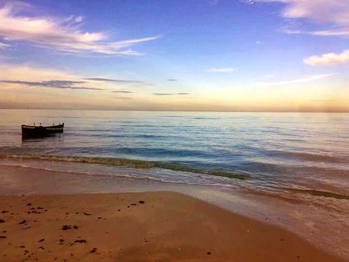 sea, water, horizon over water, sky, beach, scenics, tranquil scene, sunset, tranquility, beauty in nature, shore, nautical vessel, cloud - sky, sand, nature, idyllic, boat, cloud, transportation, mode of transport