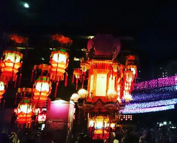 Low angle view of illuminated lanterns against sky at night