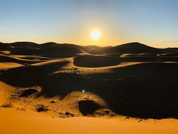 Scenic view of desert against sky during sunset