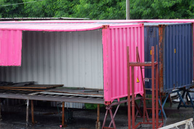 Multi colored chairs on metallic structure by lake against building