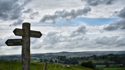 Cross on land against sky