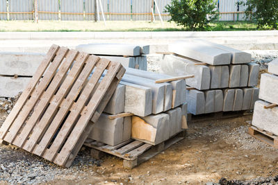 Reinforced concrete blocks neatly stacked on the territory of a fenced construction site, 