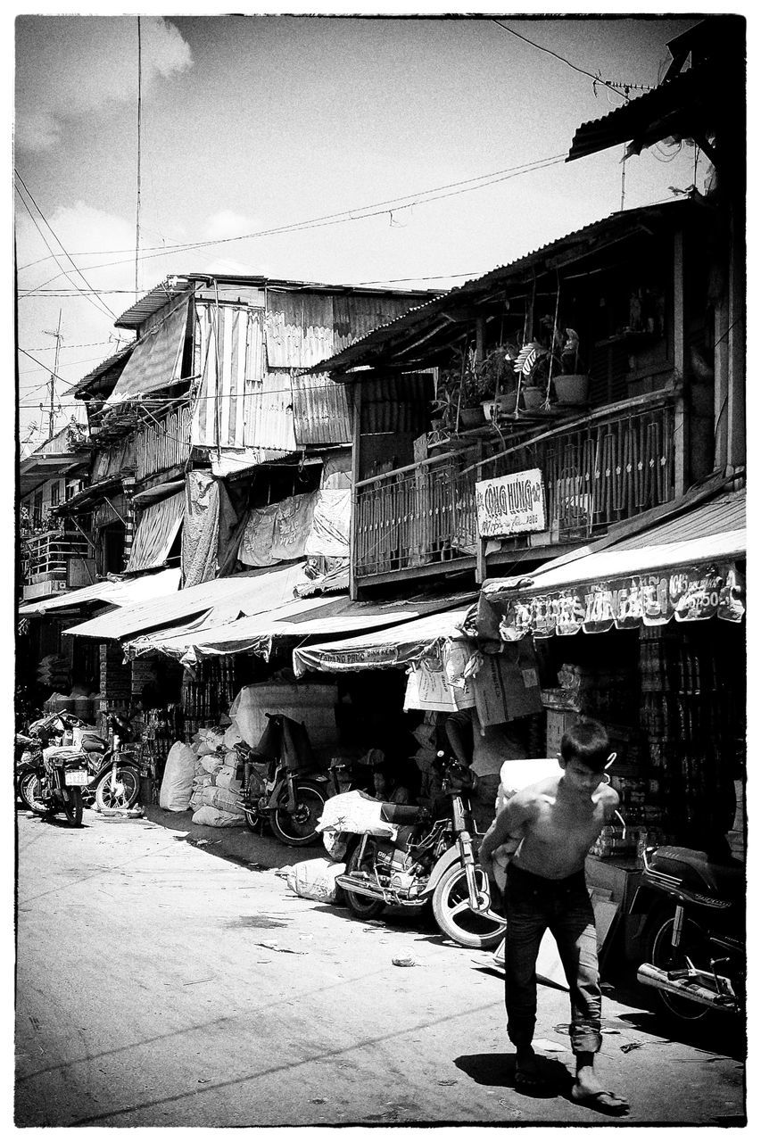 transfer print, auto post production filter, full length, men, street, walking, architecture, road, lifestyles, side view, built structure, person, building exterior, casual clothing, homelessness, day, outdoors, sack, retail