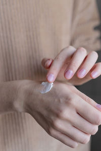 Cropped hand of woman applying nail polish