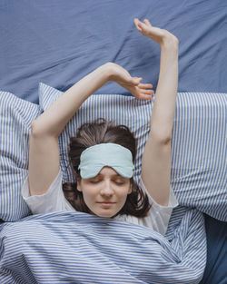 High angle view of woman sitting on bed at home