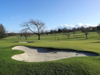 Scenic view of golf course against sky